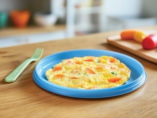 Omelette on a blue plastic plate with childrens cutlery